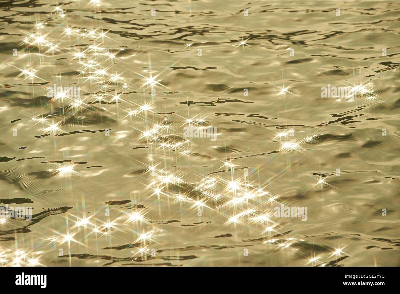 Detalle de la luz del sol que se refleja en el brillante mar. Gorrión en el agua - fondo. Agua del mar con el resplandor del sol y la ondulación. Naturaleza poderosa y pacífica c Foto de stock