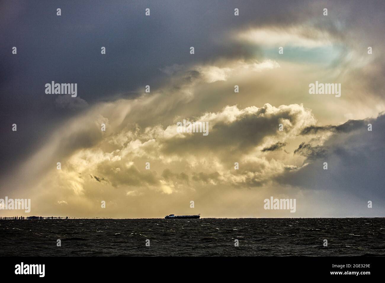 Holanda, Den Oever, nubes. Barco de carga, barcaza en IJsselmeer. Foto de stock