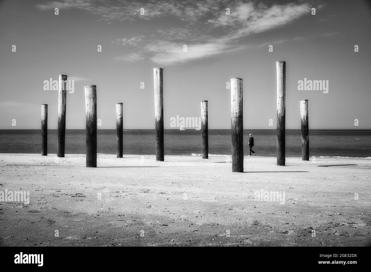 Países Bajos, Petten, Playa. Mar del Norte. Palendorp. Obras de arte con postes. Hombre, velero. Foto de stock