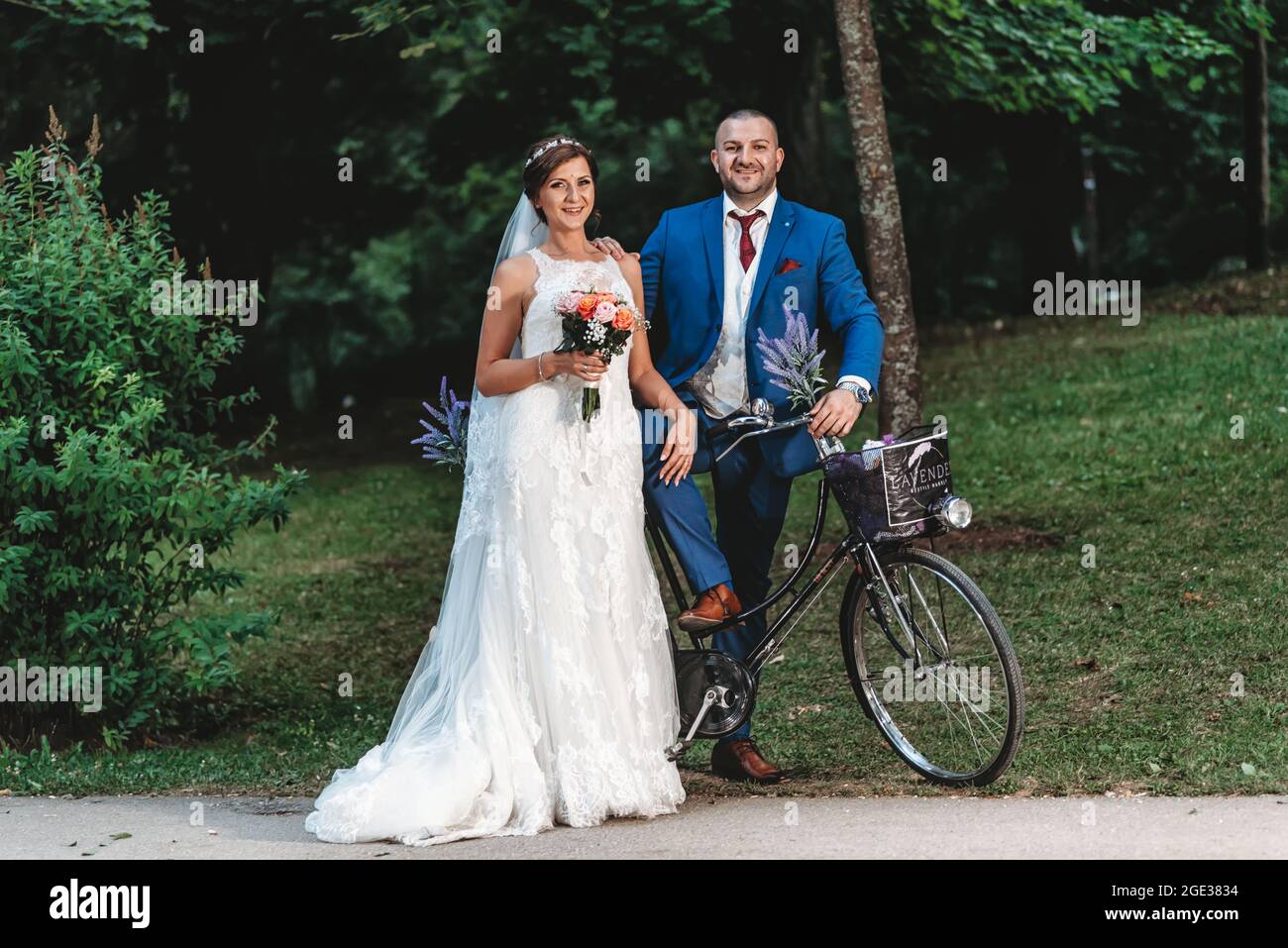 Hermosa novia en elegante vestido de boda blanco con velo largo y novio en  traje azul Fotografía de stock - Alamy