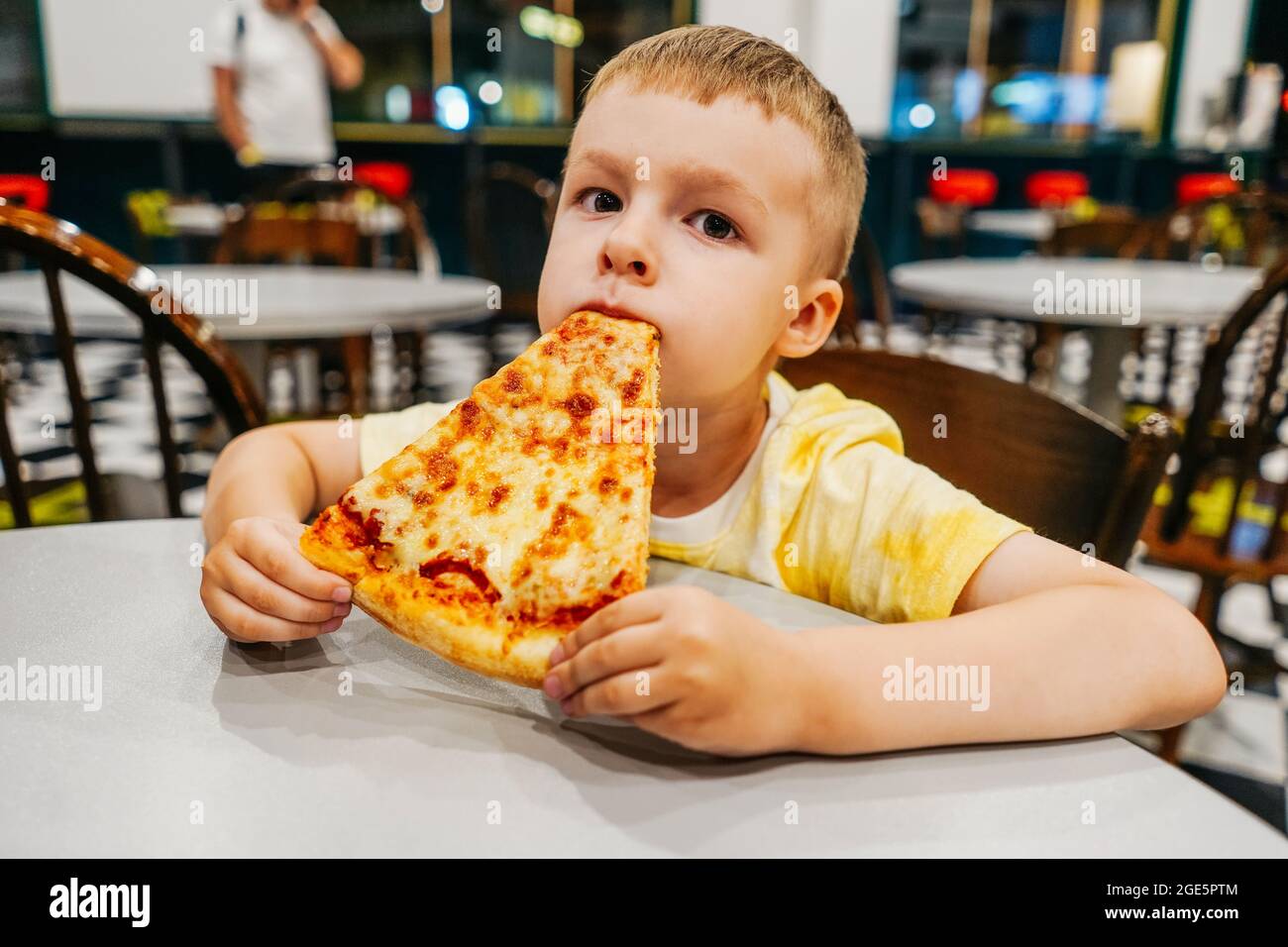 El niño come pizza en un café americano, retrato de cerca Fotografía de  stock - Alamy