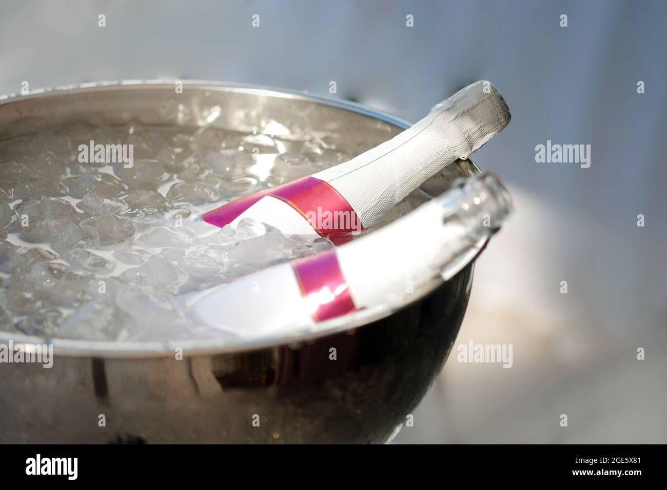 Botella de champán frío de copas, cubitos de hielo rellenos en una foto de nevera. Foto de stock