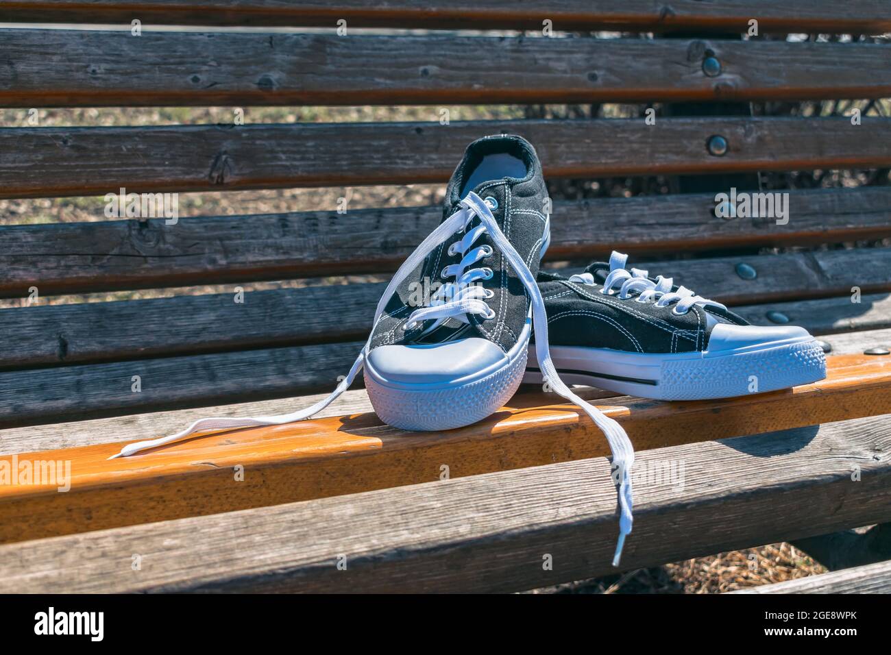 Nuevas zapatillas deportivas para caminar o correr, tumbadas en un banco de parque en verano de stock Alamy