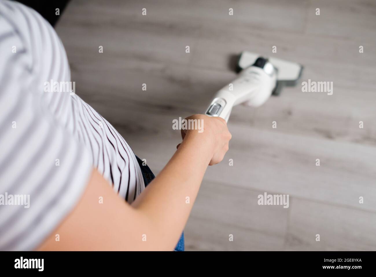 Una Persona Usa Una Aspiradora Sin Cables Blanca Para Limpiar El Sofá De La  Sala De Estar. Imagen de archivo - Imagen de interior, doméstico: 232585175