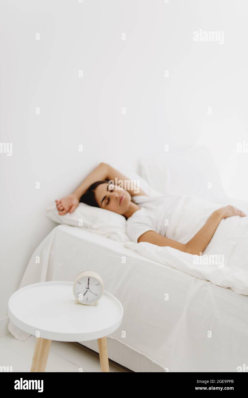 Mujer durmiendo en la cama con despertador Fotografía de stock - Alamy