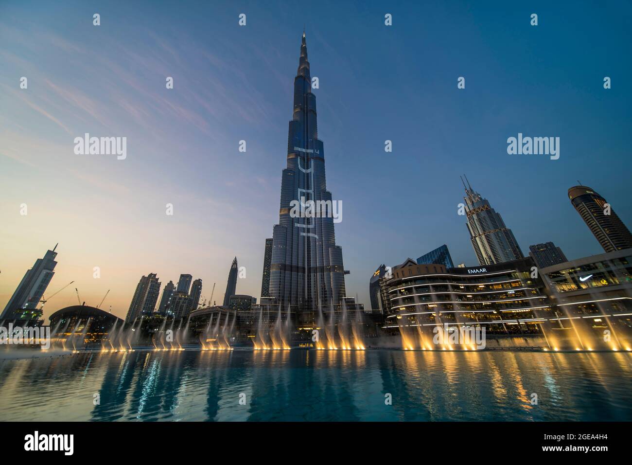 La fuente bailable cobra vida bajo el Burj Khalifa. Foto de stock