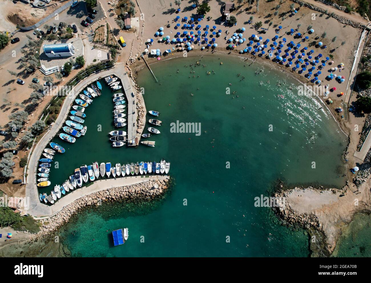 Vista aérea de la playa con gente nadando y barcos de pesca amarrados en el puerto. Protaras Paralimni Chipre Foto de stock