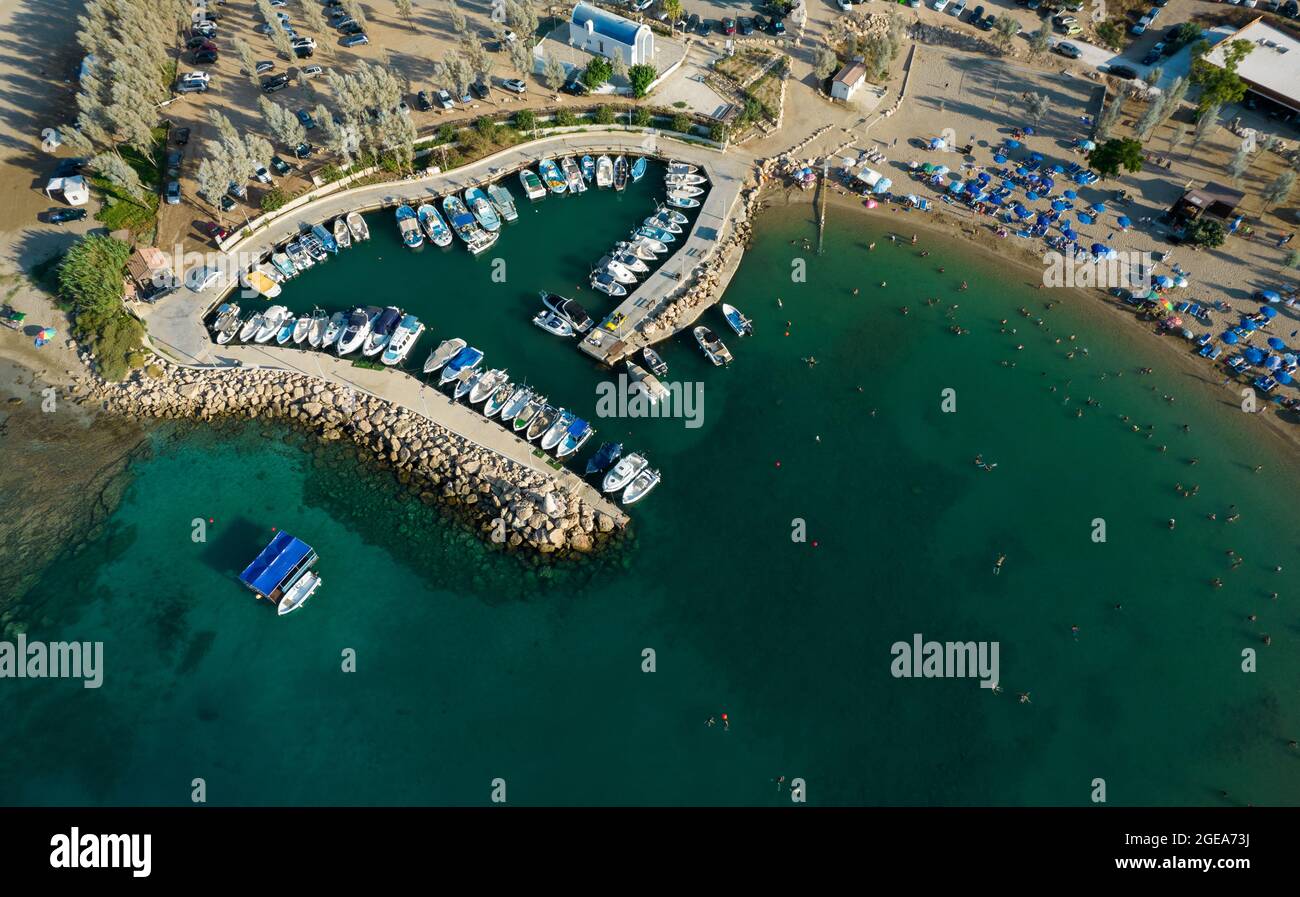 Vista aérea de la playa con gente nadando y barcos de pesca amarrados en el puerto. Protaras Paralimni Chipre Foto de stock