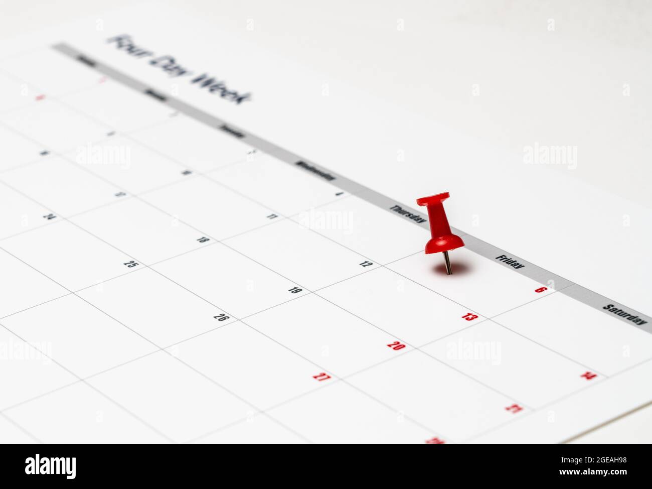Calendario impreso para una semana laboral de 4 días que muestra los días de fin de semana en rojo en un nuevo enfoque de la productividad Foto de stock