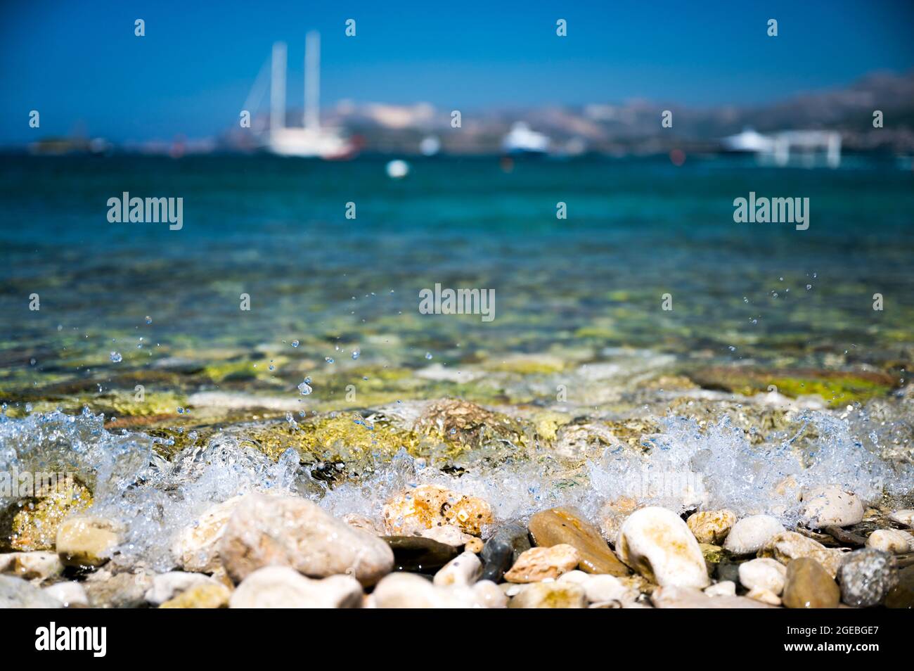 Olas frescas, refrescantes y atractivas rompiendo en los guijarros de la costa de Cavtat, Croacia Foto de stock