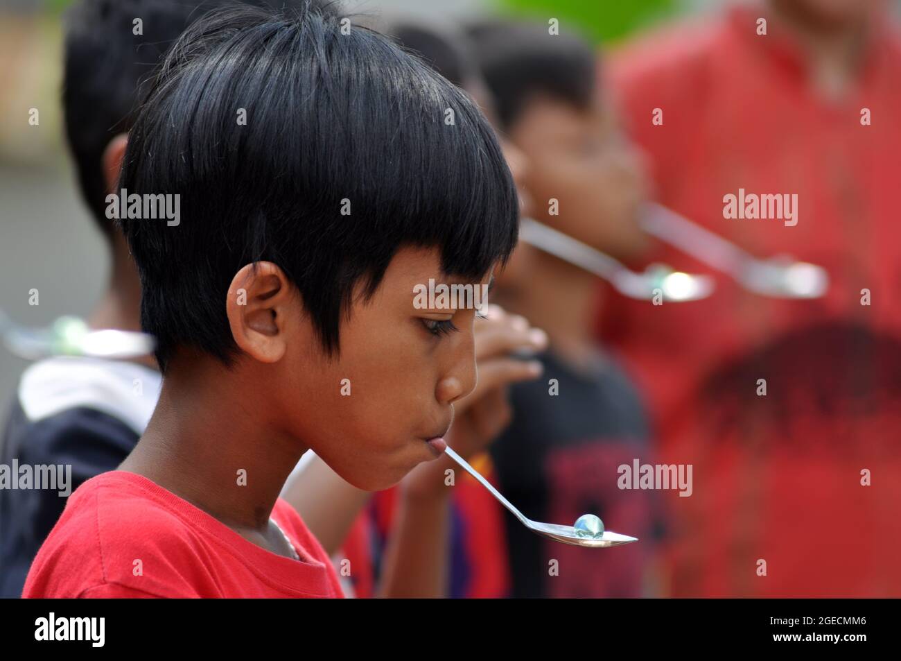 Java Occidental, Indonesia - 17 de agosto de 2021 : Los niños participan en  un concurso para llevar canicas usando cucharas en la celebración de la  Independe Fotografía de stock - Alamy