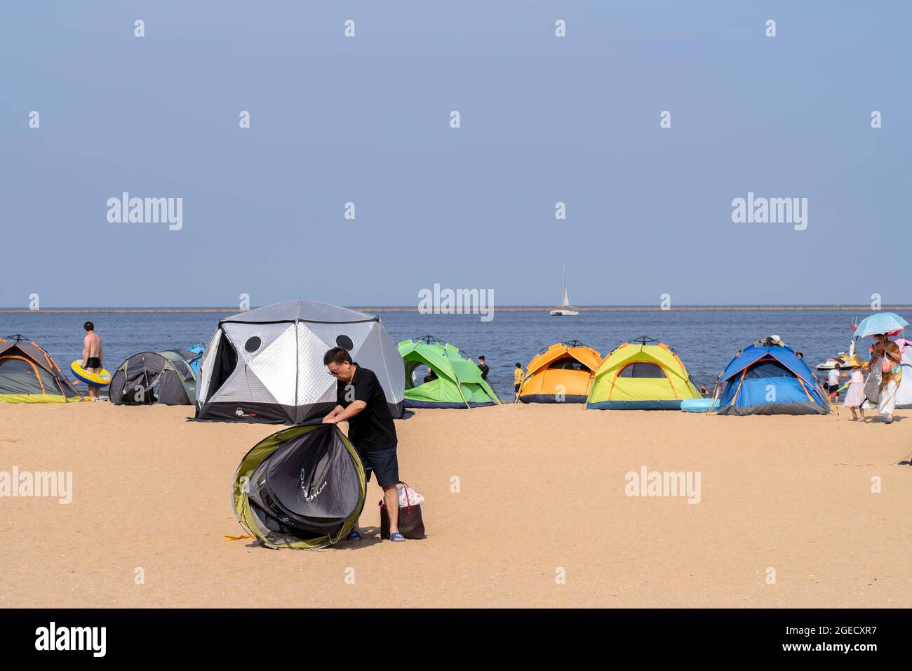 la gente disfruta de su tiempo de acampada en las arenas de la playa. Foto de stock