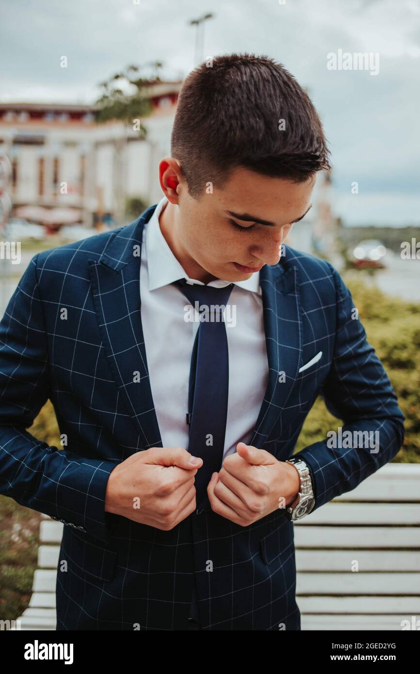 Primer plano de un joven hombre guapo con un traje azul de cuadros, corbata  y camisa blanca Fotografía de stock - Alamy