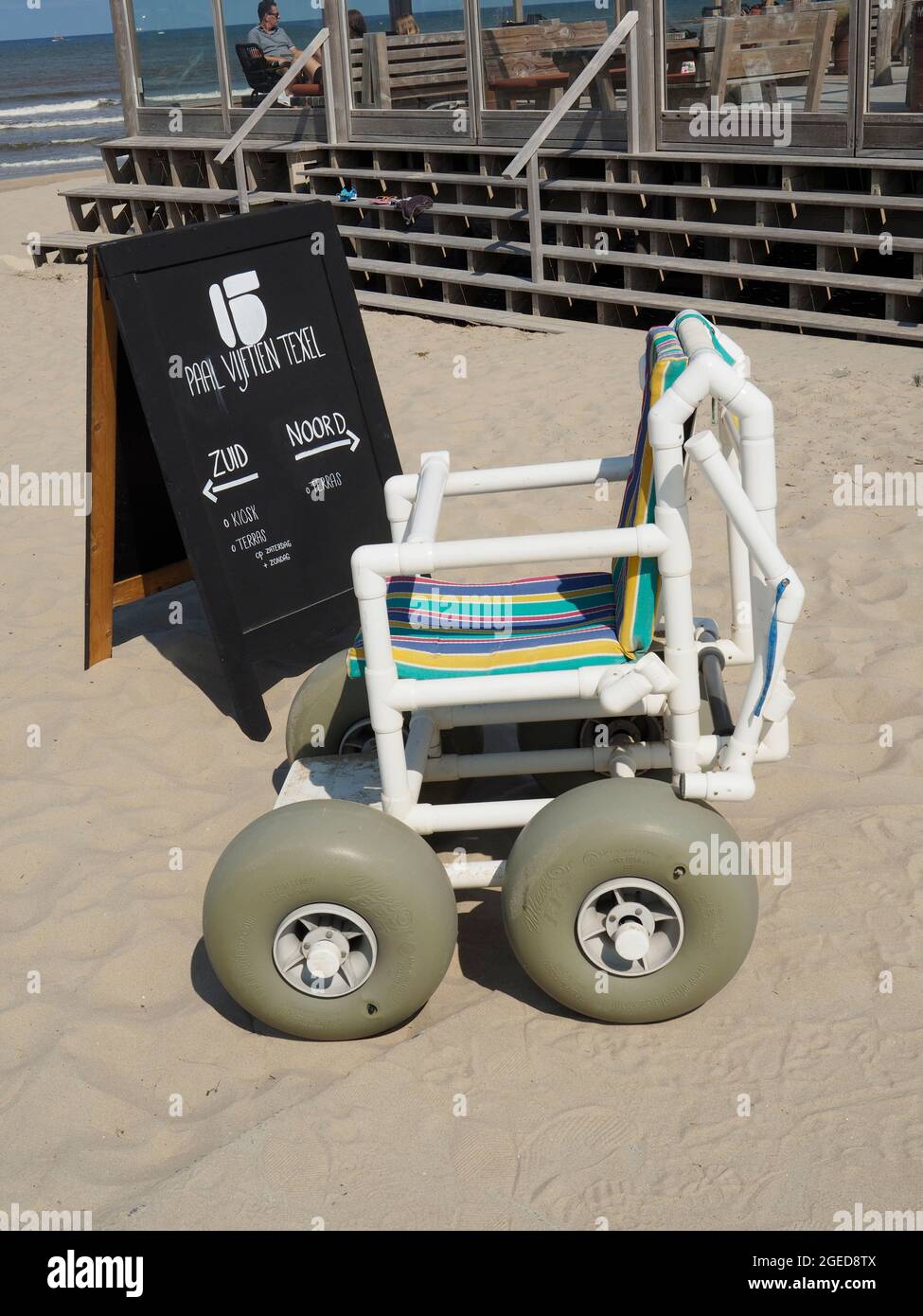 Silla especial de playa para dar a las personas con discapacidad la posibilidad de disfrutar de la playa en Paal 15, en la isla de Texel, Países Bajos Foto de stock