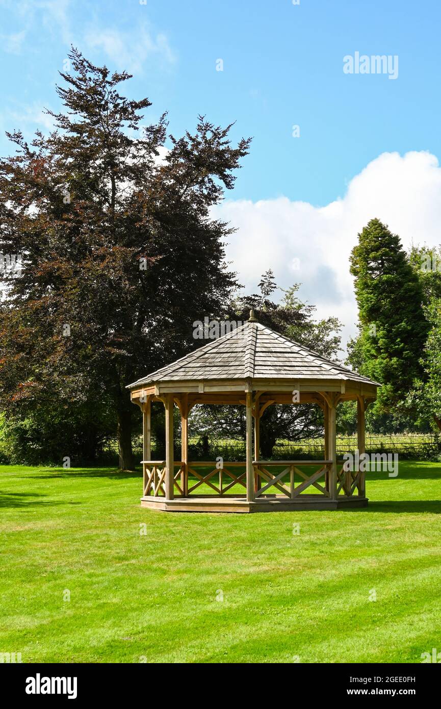 Basingstoke, Inglaterra - 2021 de agosto: Bandstand octagonal de madera en un jardín paisajista Foto de stock