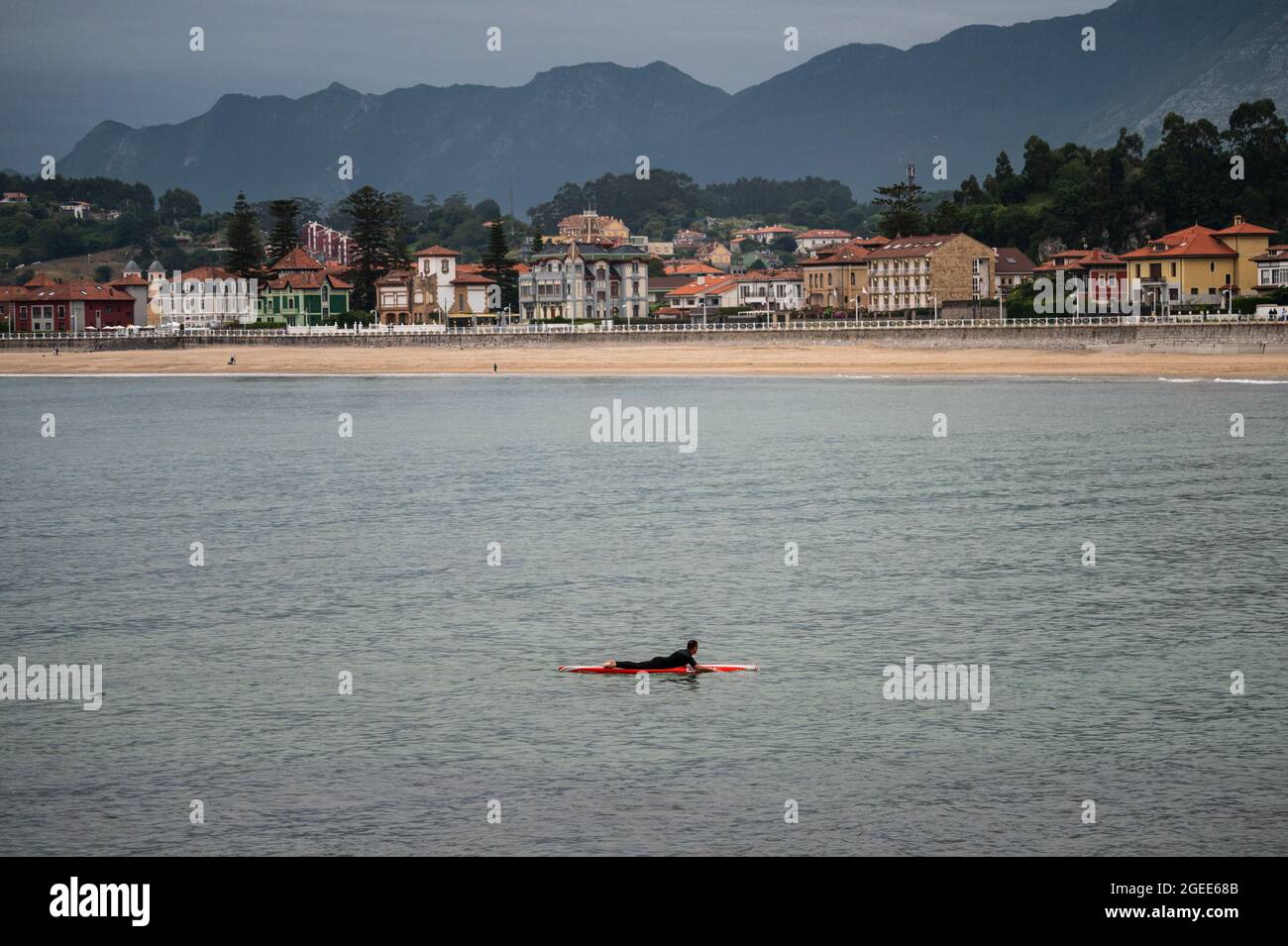 Un hombre con tabla de surf en Santa Marina Beach, Ribadesella, durante el verano. Foto de stock