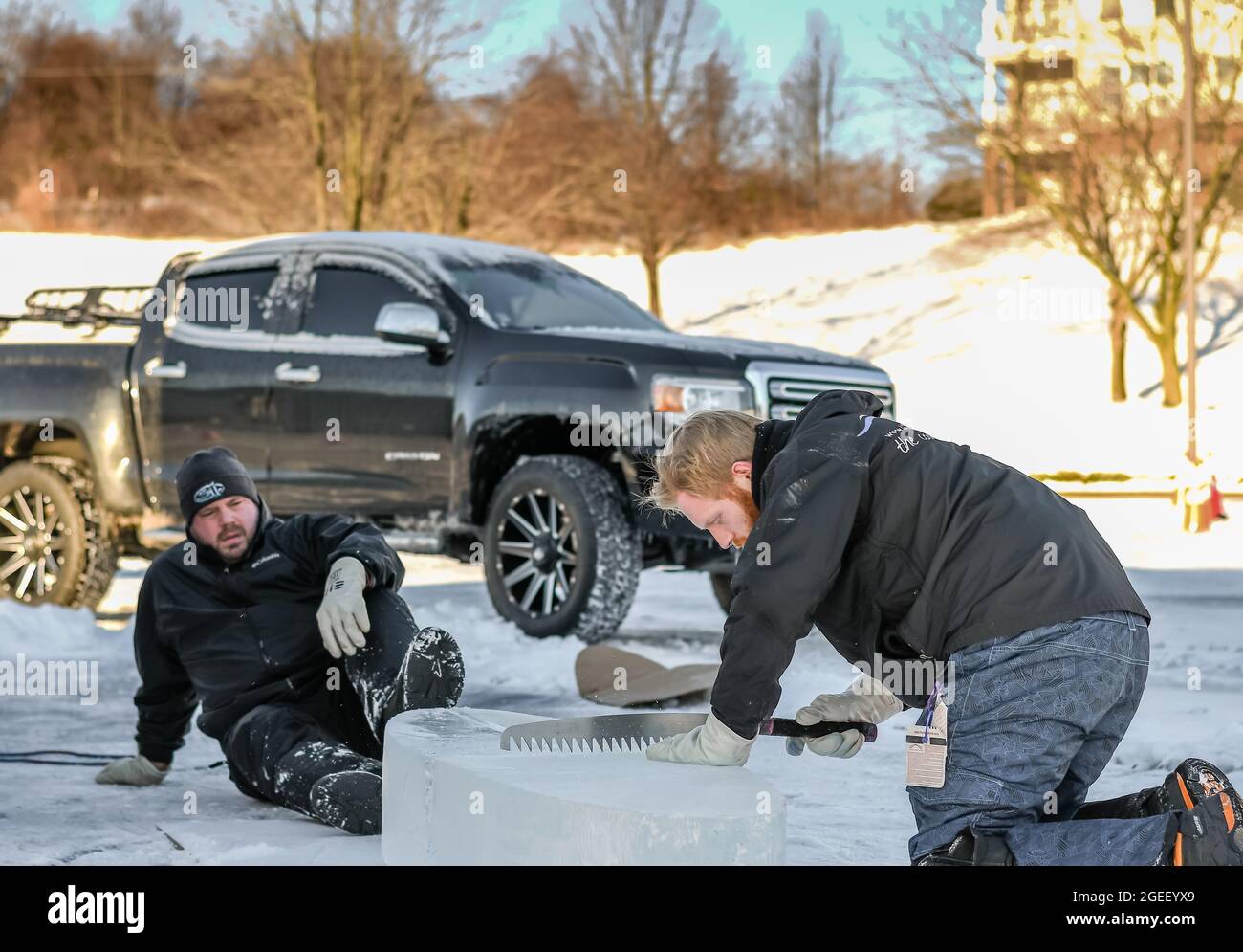 Dos talladores de hielo profesionales esculpiendo bloque de hielo Foto de stock