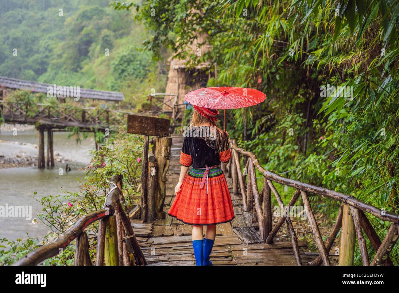 Una turista femenina vestida con el vestido tradicional de los habitantes de las montañas vietnamitas, el Hmong. Mujer en Sapa en la niebla, Noroeste Foto de stock