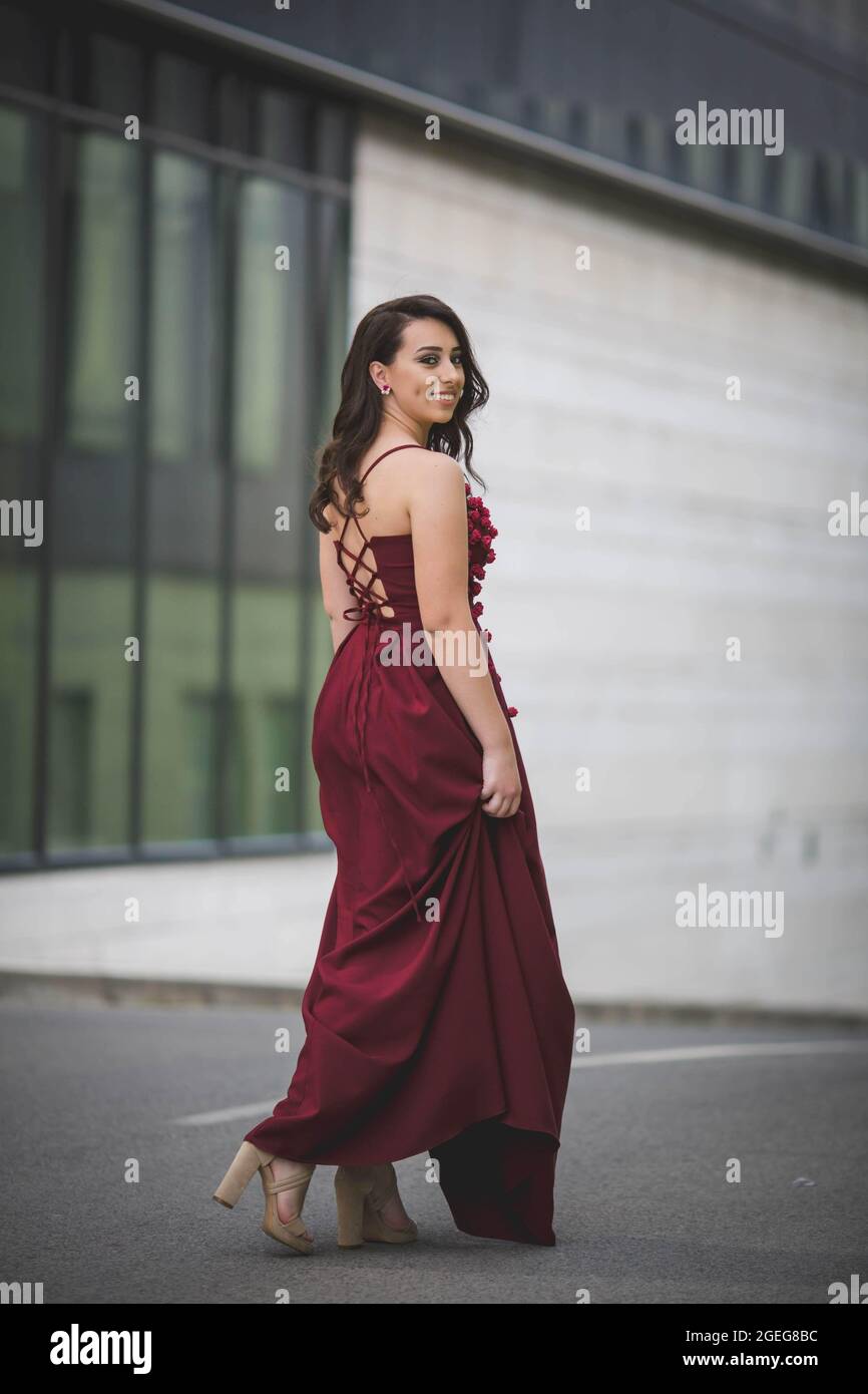 Hermosa morena con un vestido de color borgoña Fotografía de stock - Alamy