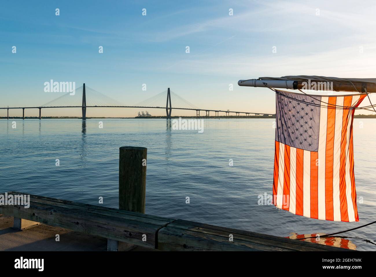 La bandera estadounidense colgando de la barriada de un barco en el río Cooper frente al puente Arthur Ravenel Jnr en Charleston, Carolina del Sur, Estados Unidos Foto de stock