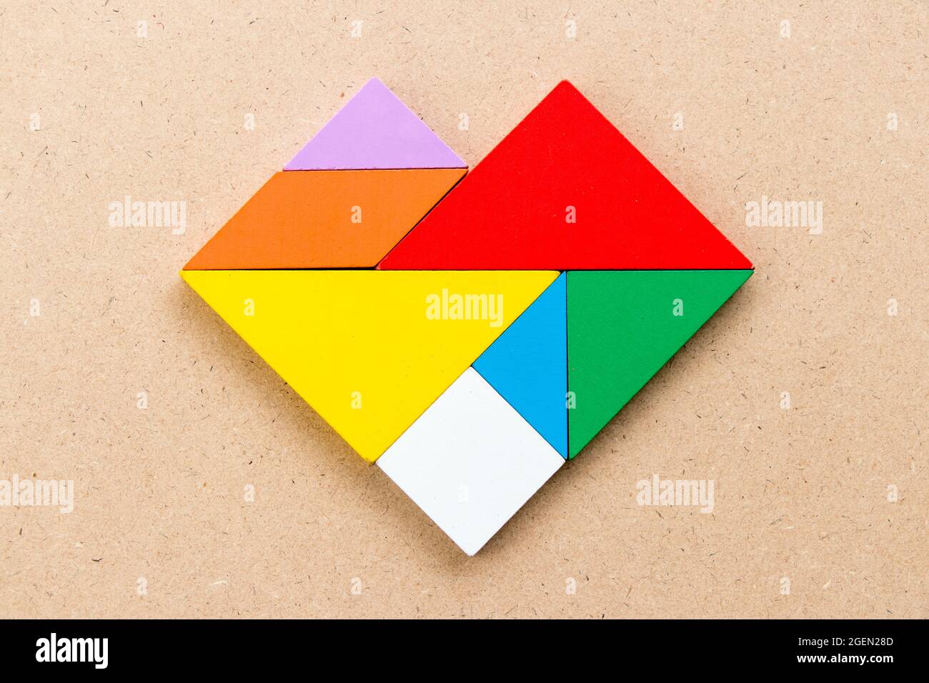 Rompecabezas de color tangram en forma de corazón sobre fondo de madera  Fotografía de stock - Alamy