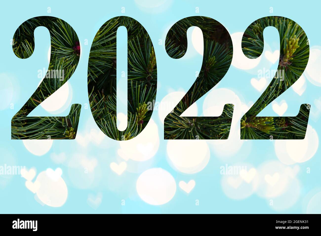Números 2022 de ramas de pino cerca de un fondo azul claro con un hermoso bokeh, fondo natural de Navidad. Tarjeta de Año Nuevo para 2022 Foto de stock