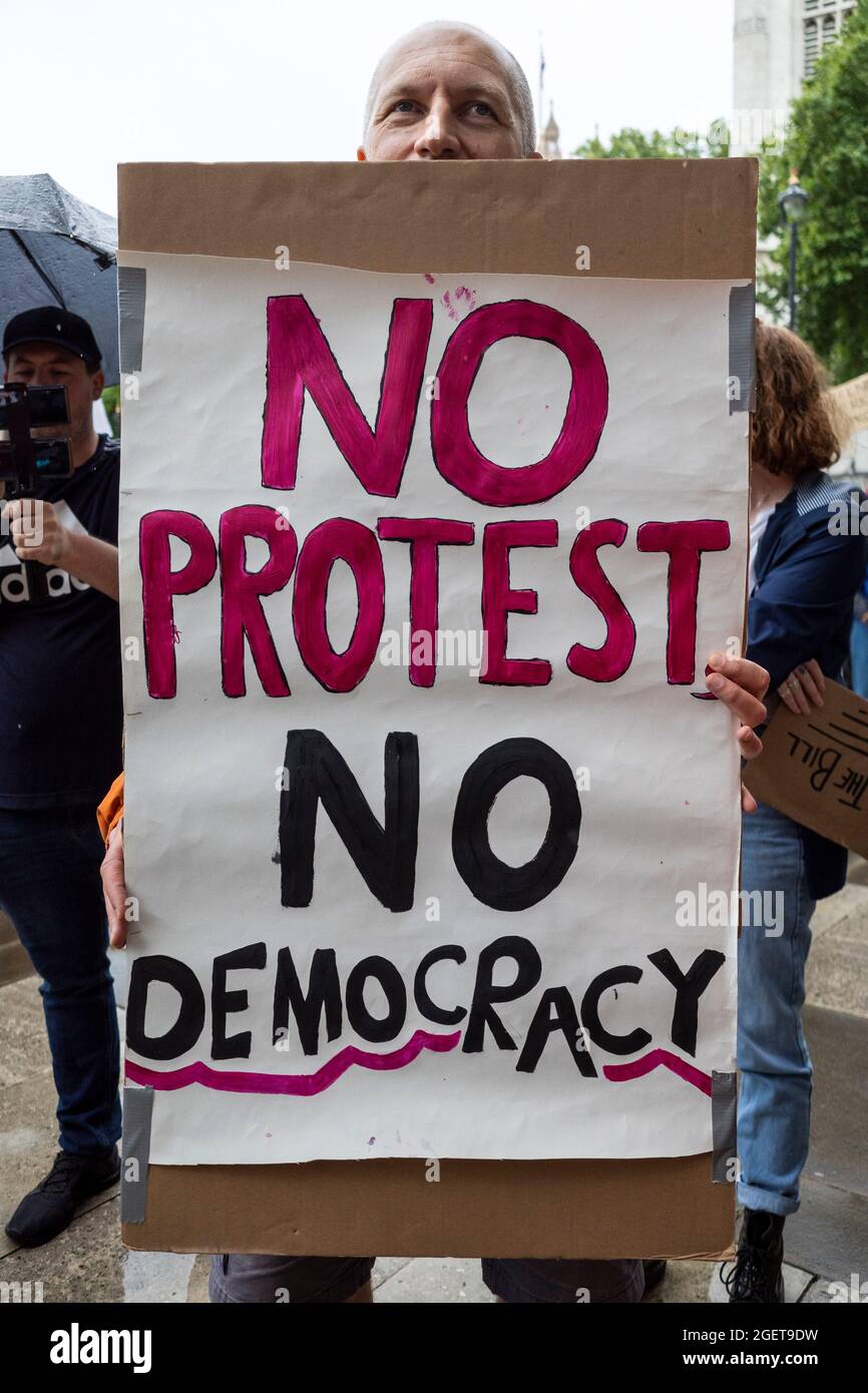 Londres, Reino Unido. 21 de agosto de 2021. Un hombre sostiene un cartel en una protesta de Kill the Bill en la Plaza del Parlamento donde la gente está haciendo campaña contra la Ley del Gobierno contra la Policía, el Crimen, las Sentencias y los Tribunales. Los miembros de los activistas climáticos Extinction Rebellion (XR) también están presentes antes de las protestas climáticas que se reportan contra la ciudad de Londres la próxima semana. Crédito: Stephen Chung / Alamy Live News Foto de stock