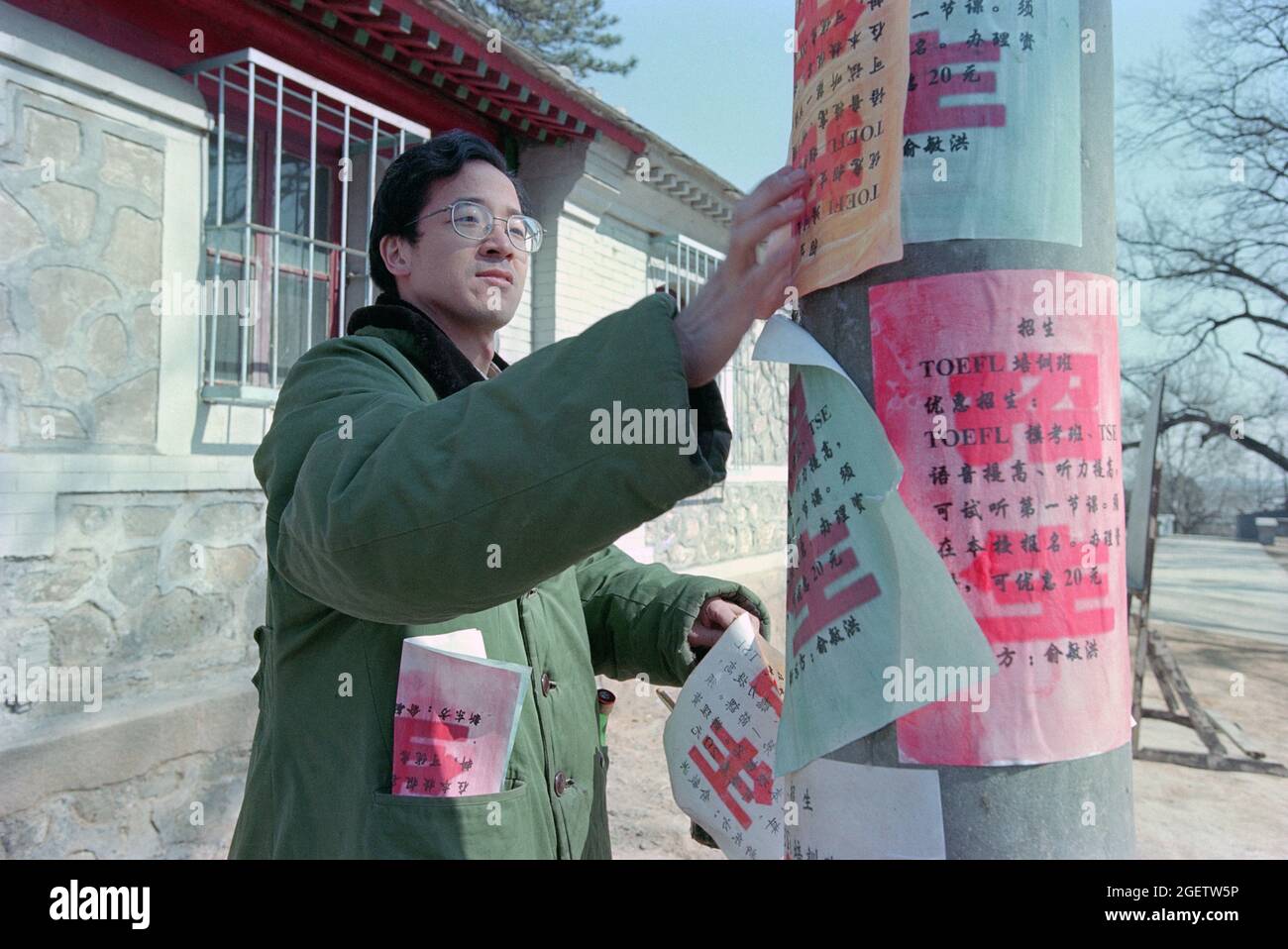 Yu Minhong reproduce el trabajo duro temprano de comenzar un negocio—publicando anuncios para la formación en inglés y la inscripción a lo largo de la calle.2000 Foto de stock