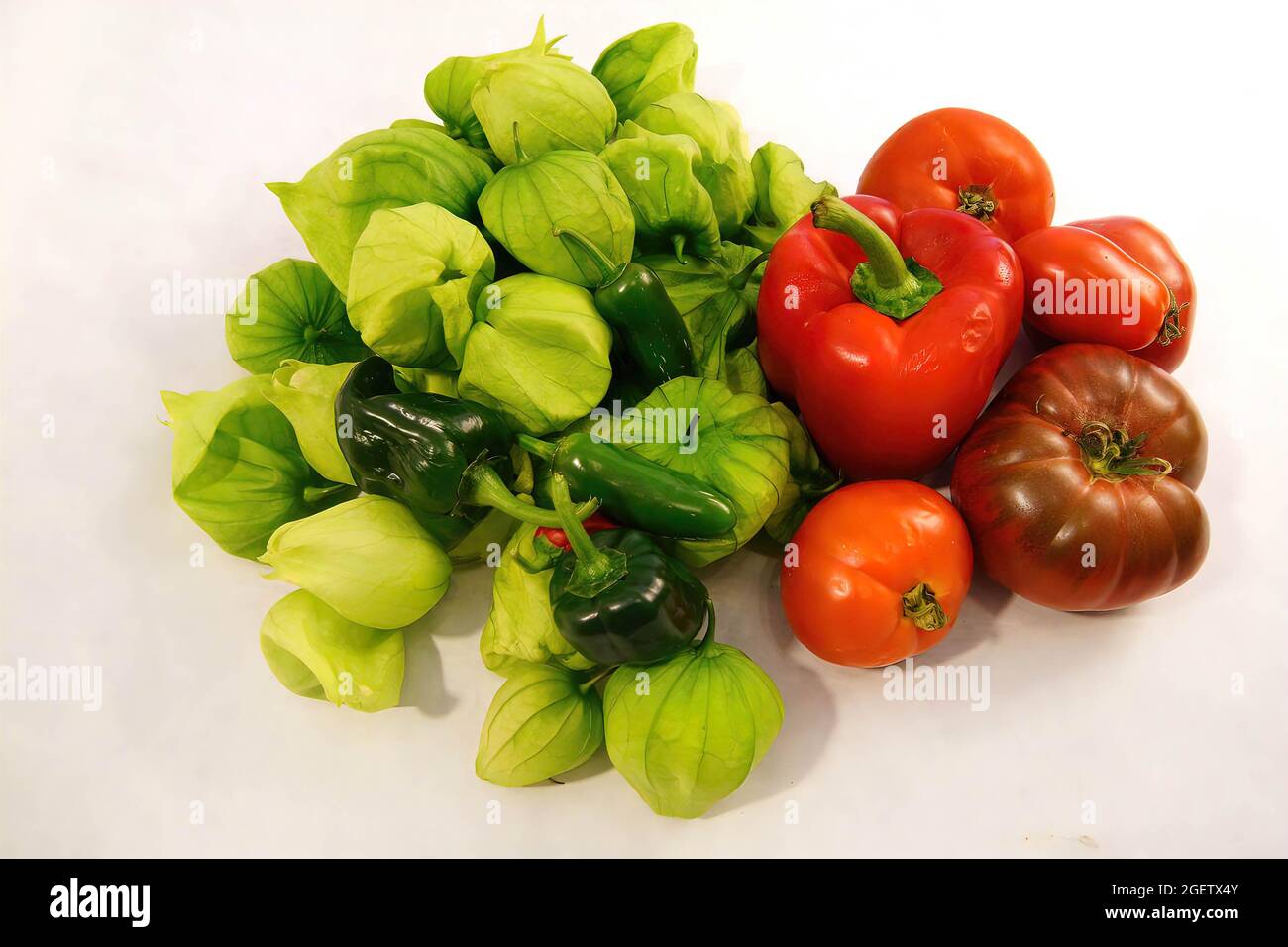 Tomatillo verde, tomates y pimientos de chile para salsa, frescos del jardín de Seattle aislados sobre blanco Foto de stock