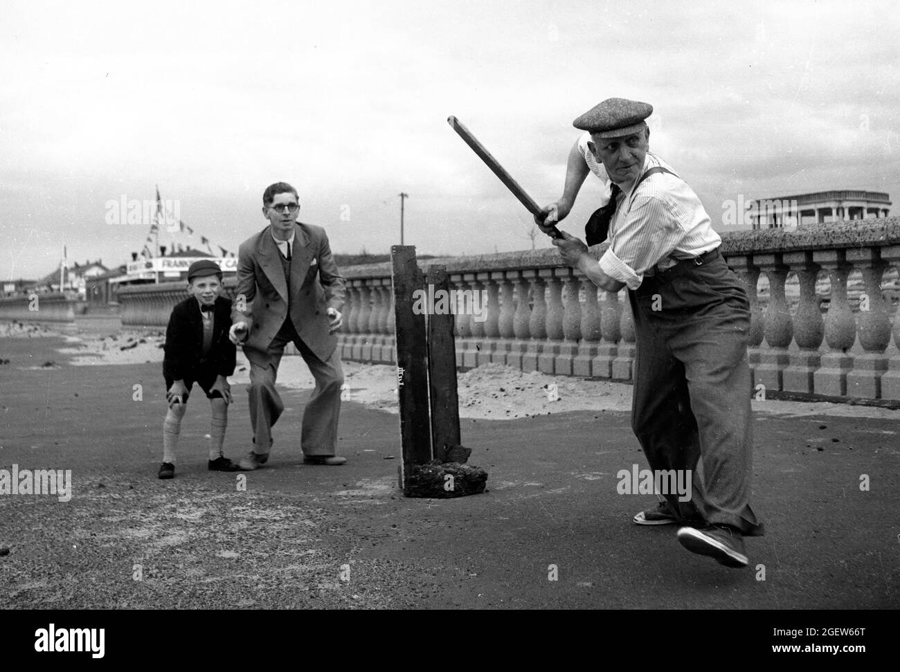 Familia jugando cricket improvisado en la costa de Gran Bretaña 1950s Foto de stock
