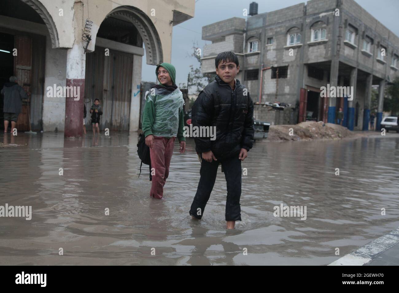 Los niños palestinos caminan en agua inundada. Ciudad de Gaza. Foto de stock