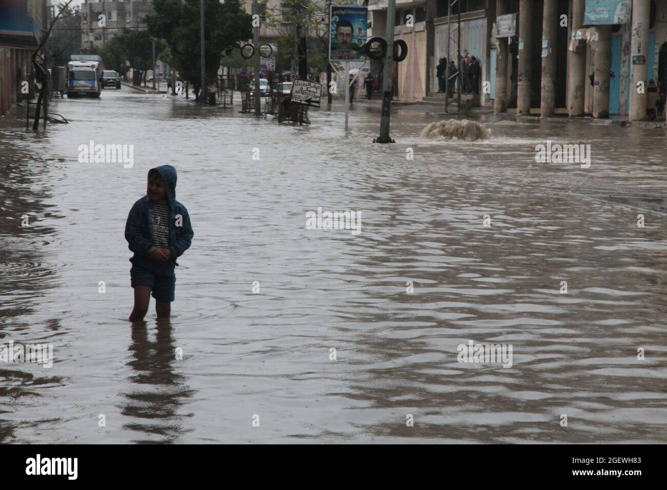 Los niños palestinos caminan en agua inundada. Ciudad de Gaza. Foto de stock