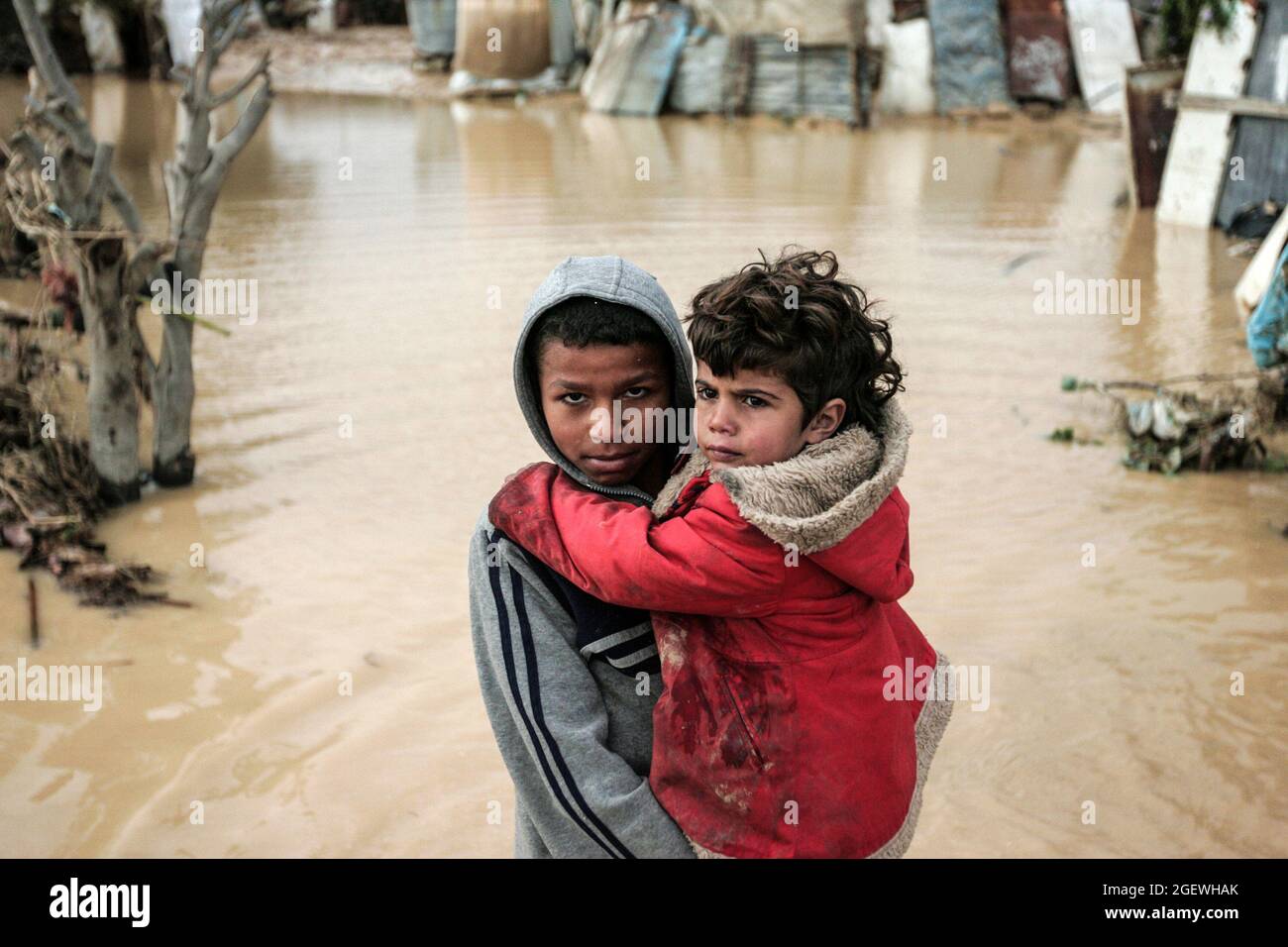 Retrato de niños palestinos caminando en agua inundada. Ciudad de Gaza. Foto de stock
