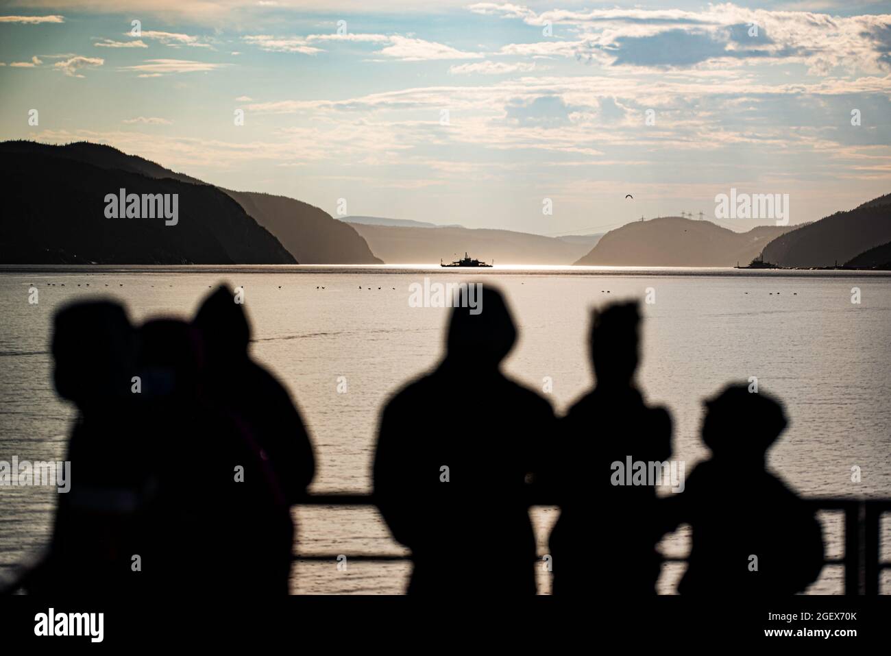Tadoussac, Canadá - 23 de julio de 2021: Vista de la puesta de sol de la gente de la silueta y del estuario del río Saguenay en Tadoussac Foto de stock