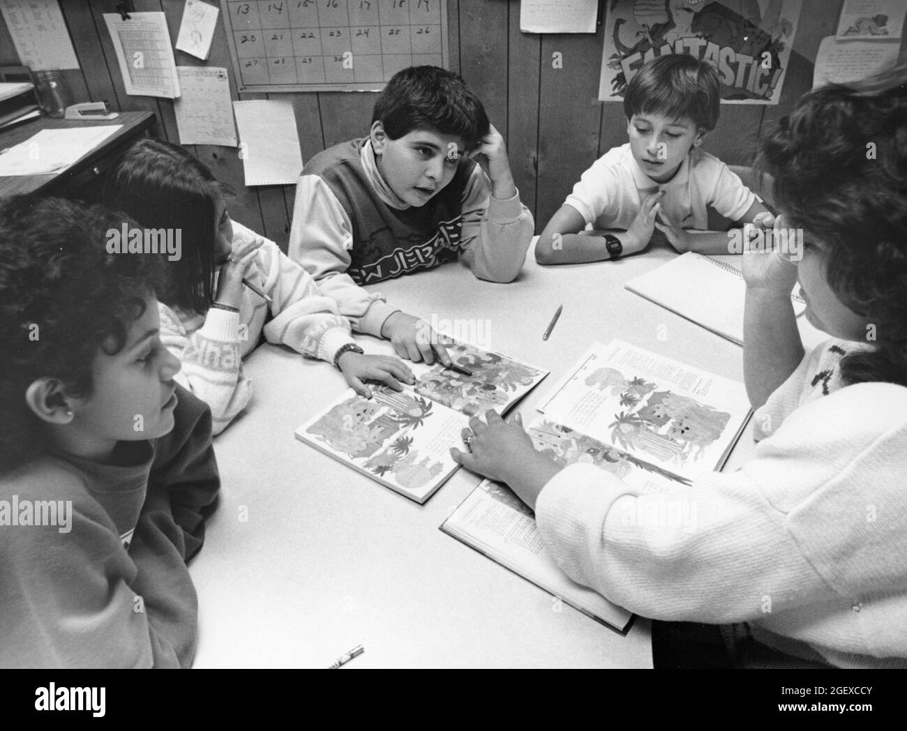 Austin Texas USA, circa 1991: Maestra de escuela primaria pública que trabaja con estudiantes de inglés como segundo idioma (ESL) en su salón de clases. ©Bob Daemmrich Foto de stock