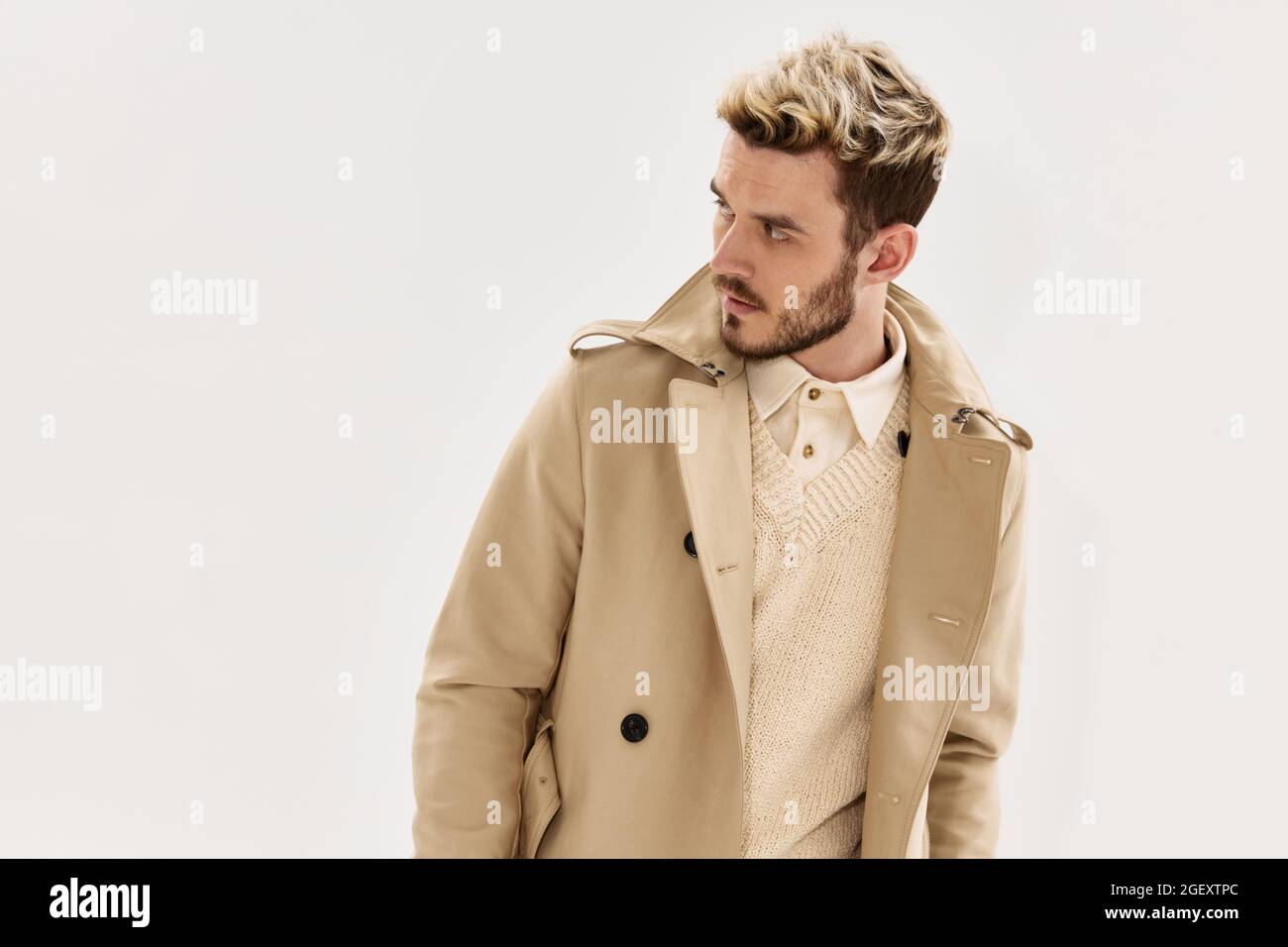 hombre con moderno peinado beige abrigo lado mirada glamour ropa Fotografía  de stock - Alamy