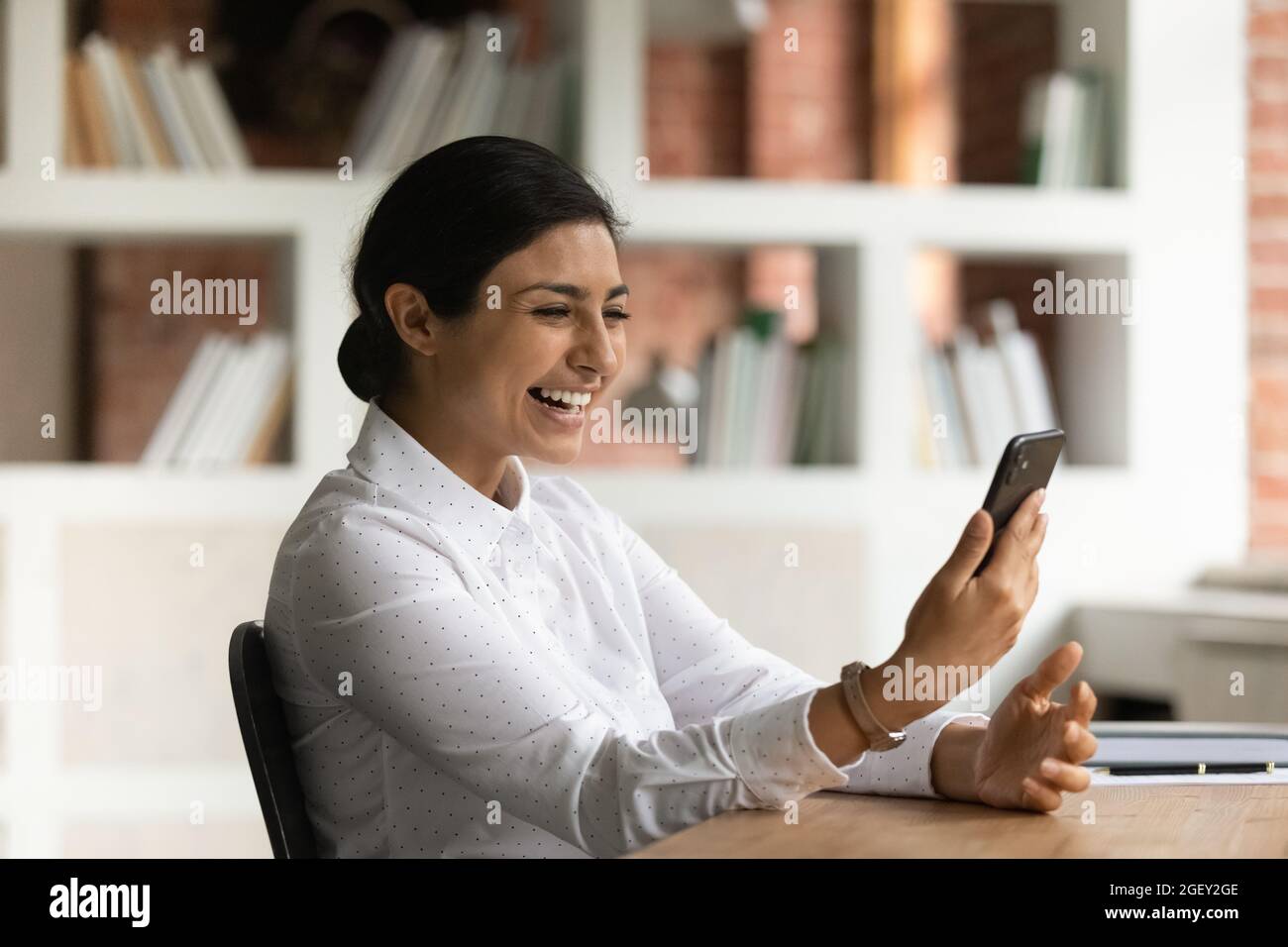 La mujer feliz leyó sms en el teléfono móvil goza de buenas noticias en línea Foto de stock