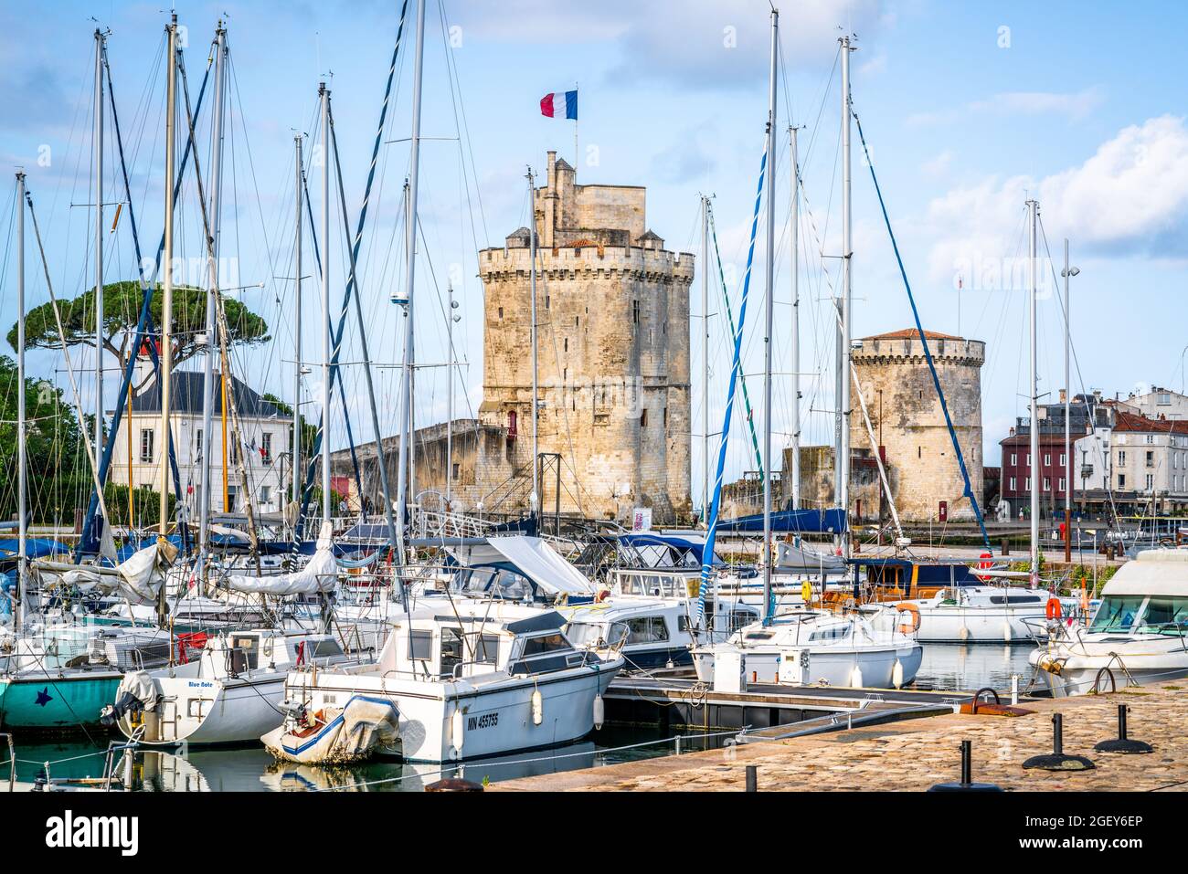28 de julio de 2021 , La Rochelle Francia : La cadena y las torres de San Nicolás de La Rochelle en medio de los barcos de vela del antiguo puerto de La Rochelle Francia Foto de stock