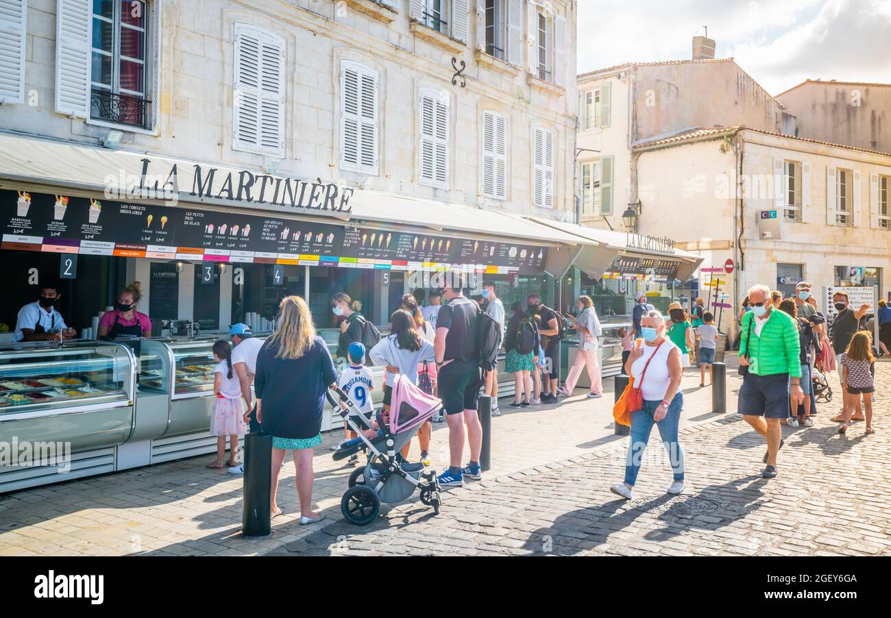 30 de julio de 2021 , Saint-Martin-de-Ré Francia : Los turistas hacen cola en la tienda de helados La Martinière en el antiguo puerto de Saint-Martin-de-Ré, un famoso arte local Foto de stock