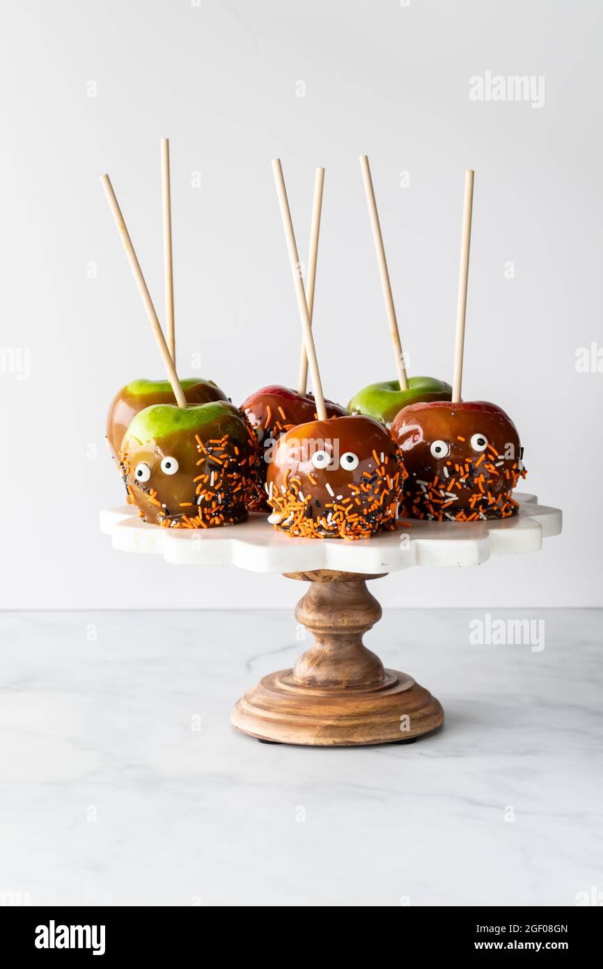 Manzanas de caramelo decoradas para Halloween en un pedestal, sobre un  fondo claro Fotografía de stock - Alamy