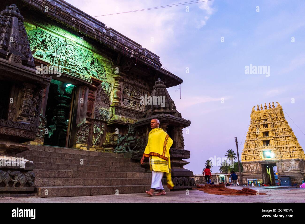 Belur, Karnataka, India : Templo Channakeshava del siglo 12th. Un sacerdote hindú circunbaliza al atardecer el templo principal de Kesava. Foto de stock