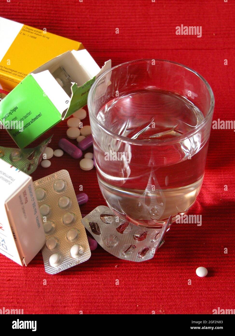 pastillas con envases de ampollas y vaso de agua, adicción a las pastillas Foto de stock