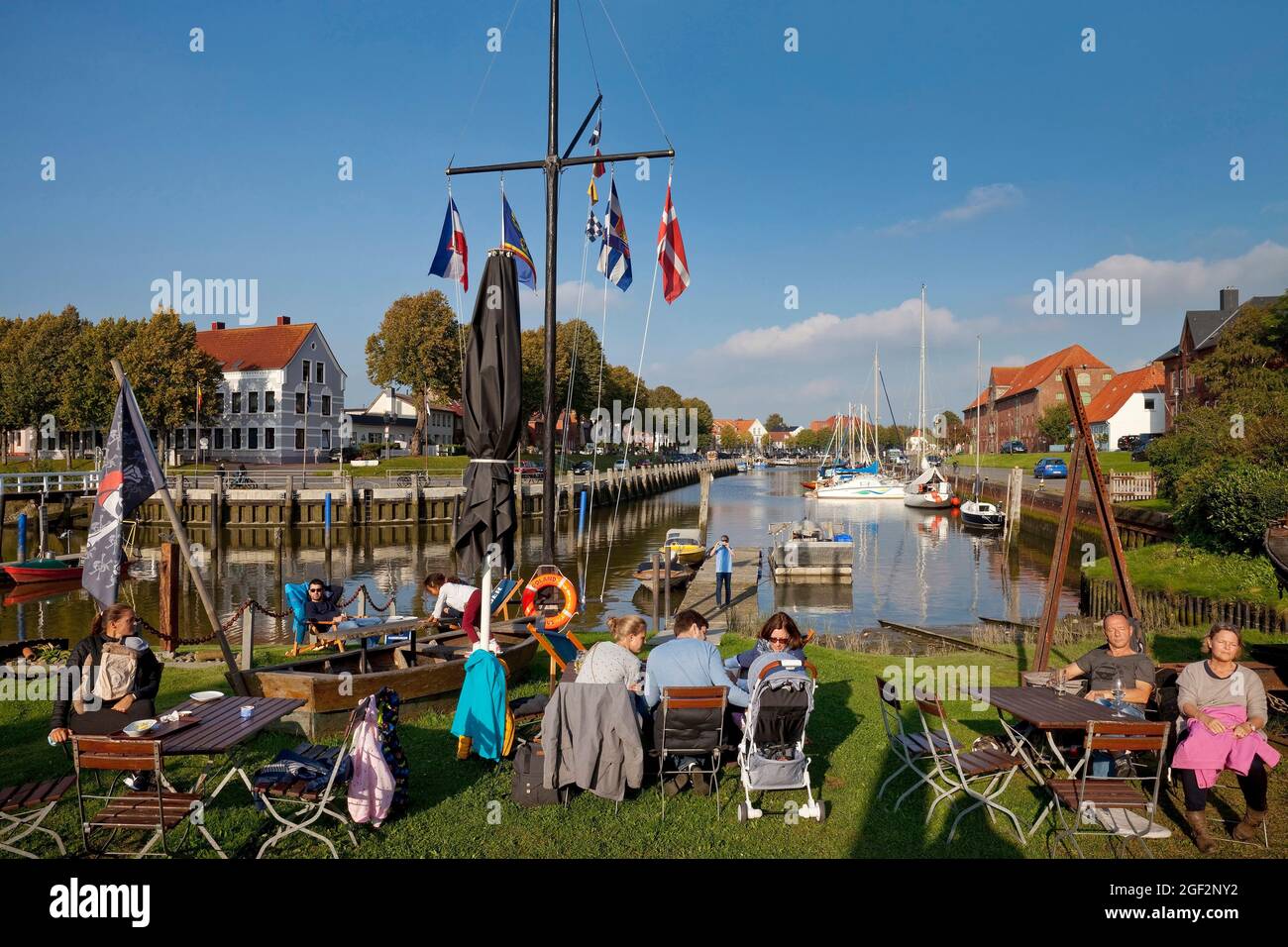 Gente en el jardín de la cerveza del antiguo astillero en frente del puerto histórico, Alemania, Schleswig-Holstein, Frisia septentrional, Toenning Foto de stock