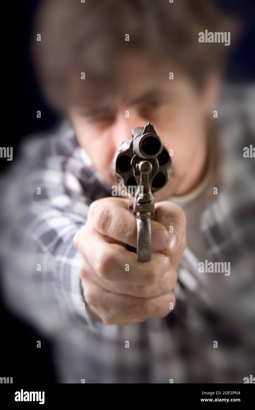 hombre apuntando con un arma de fuego, vista frontal Foto de stock