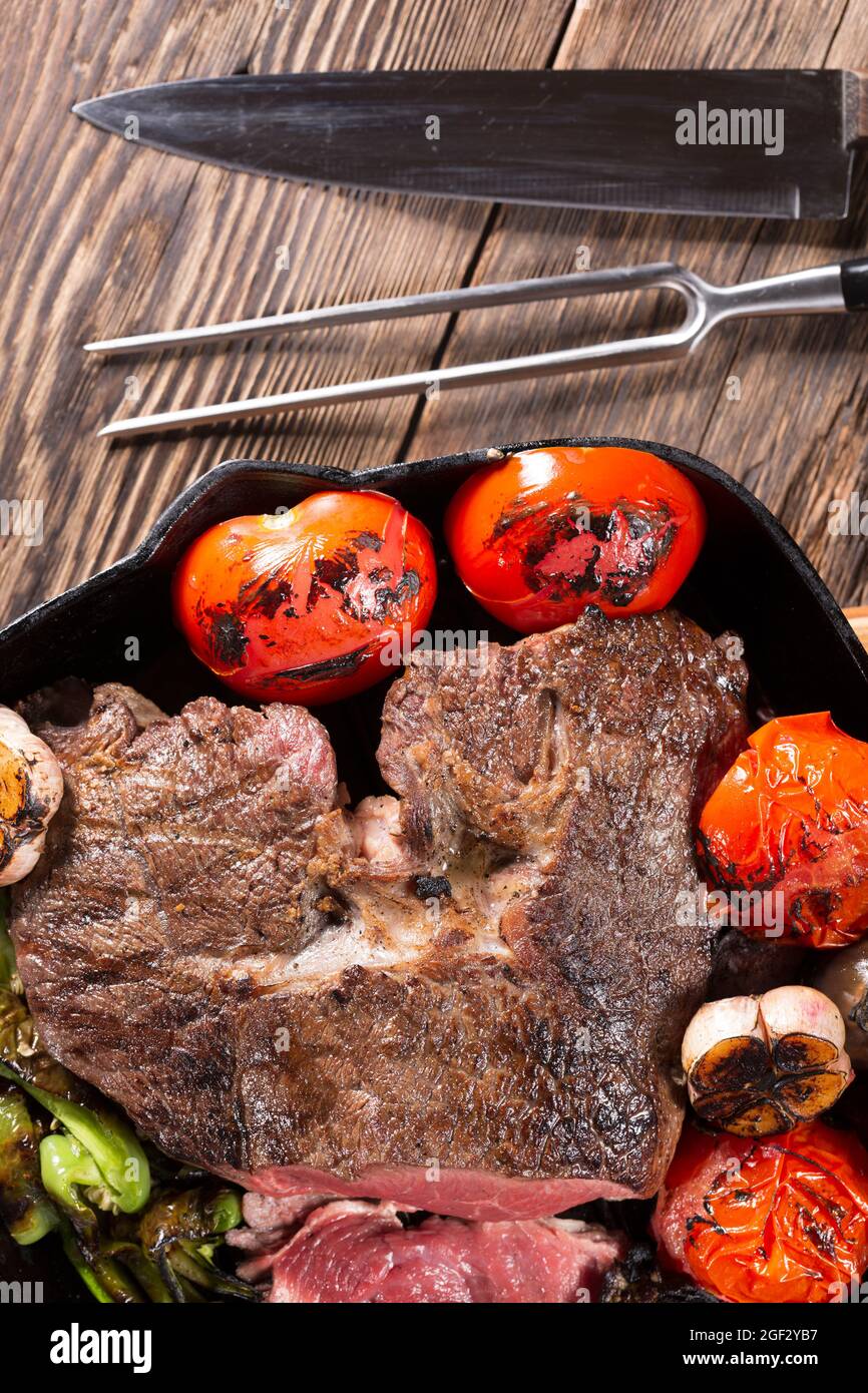 Un trozo de carne a la parrilla en una sartén de hierro fundido con  verduras, closeup Fotografía de stock - Alamy