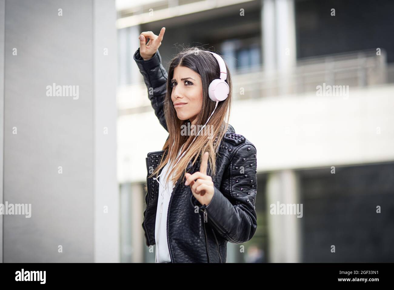 joven morena escuchando música con auriculares en el entorno urbano  Fotografía de stock - Alamy