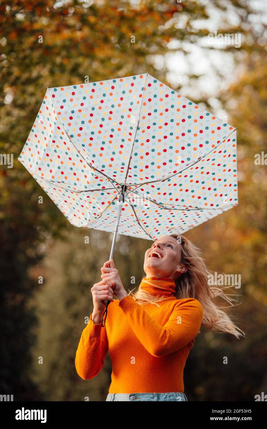 Mujer alegre mirando el paraguas al revés Fotografía de stock - Alamy