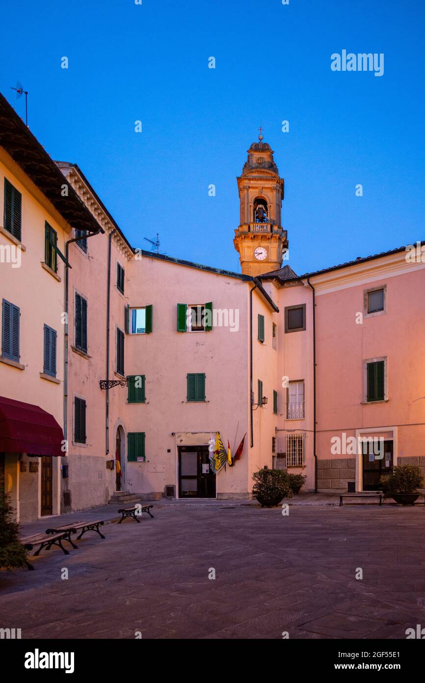 Italia, Provincia de Pisa, Pomarance, Piazza de Larderel al atardecer con el campanario de la Iglesia de San Giovanni Battista en el fondo Foto de stock