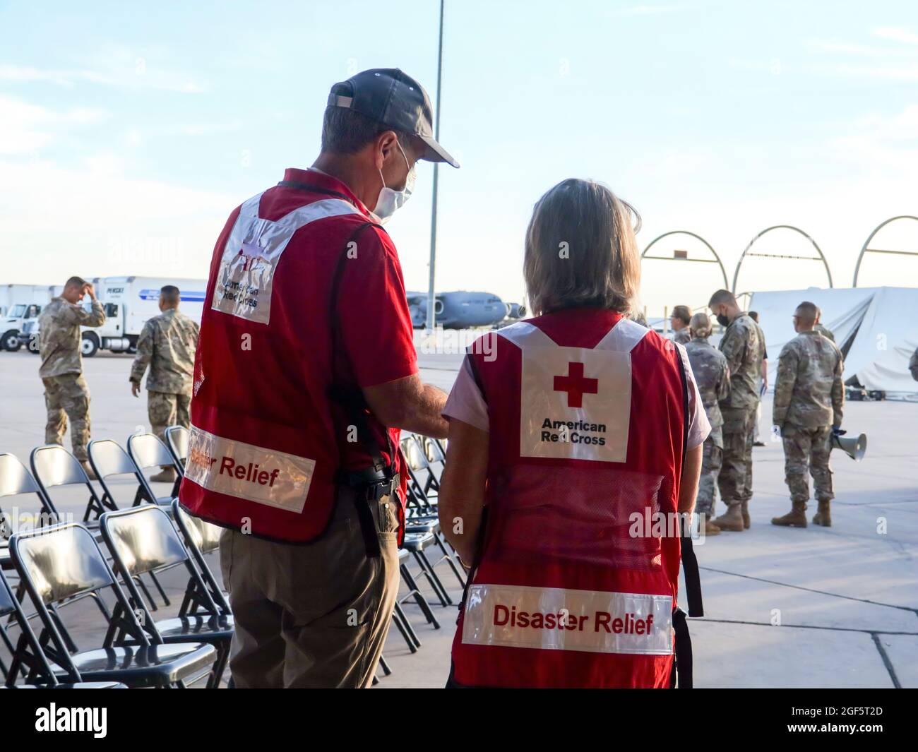 Representantes de la Cruz Roja Americana esperan la llegada del primer vuelo desde el Aeropuerto Internacional Hamid Karzai de Kabul temprano el sábado por la mañana en Fort Bliss, Tx, el 21 de agosto de 2021. El Departamento de Defensa, en apoyo del Departamento de Estado, proporciona transporte y vivienda temporal en apoyo del Refugio de la Operación Aliados. Esta iniciativa sigue el compromiso de los Estados Unidos con los ciudadanos afganos que han ayudado a los Estados Unidos y les proporciona apoyo esencial en lugares seguros fuera de Afganistán. (EE.UU Foto del ejército del Teniente Coronel Allie Payne) Foto de stock