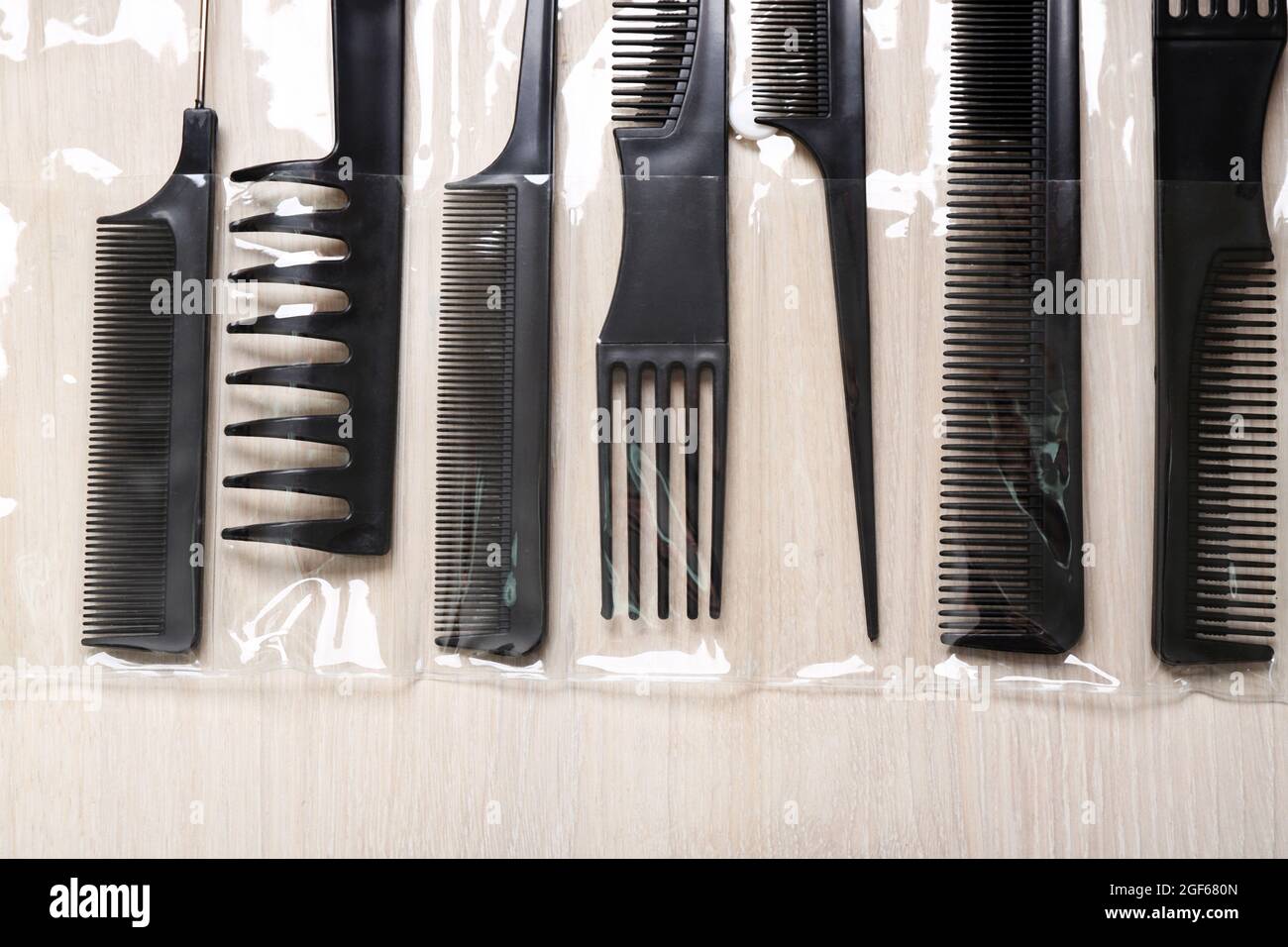 Set de peluquería con tipos de peines en la luz mesa de madera Fotografía  de stock - Alamy